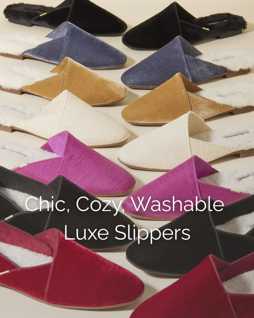 Rows of chic, cozy, machine-washable Luvons slippers in rich velvet and woven textures, arranged in jewel tones of ruby, black, cream, camel, slate blue, and raspberry.